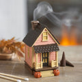 Brûleur d'encens en forme de maison rose avec des citrouilles